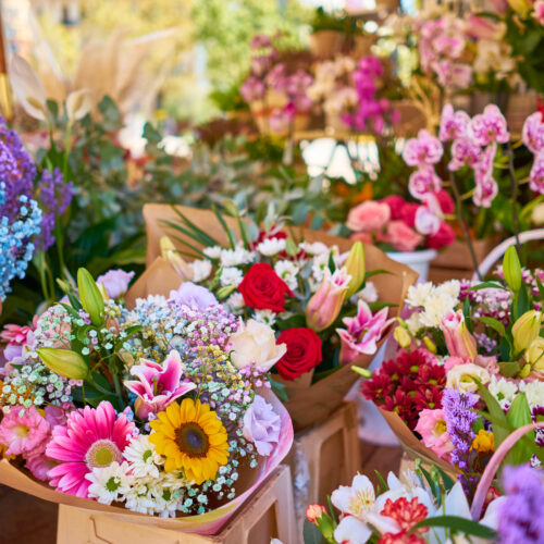 A closeup of colorful flower bouquets in containers at an outdoor shop